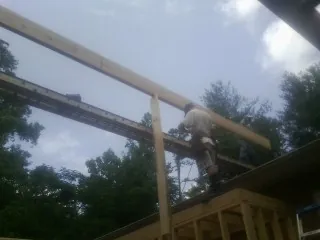 Carpenter setting a ridge beam over a new addition frame — Ice Dam Removal by Roofing Brothers in Duryea