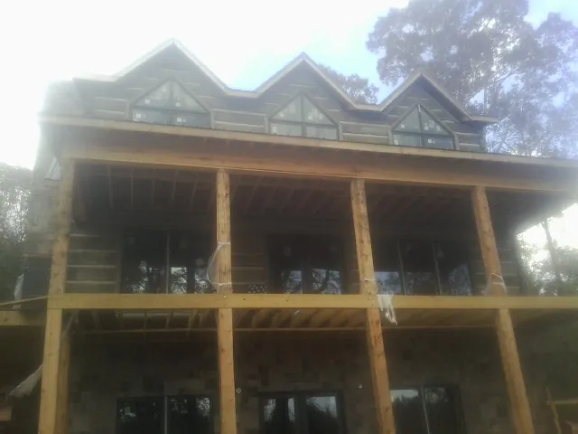 Dormers and porch framing on a large log home under construction — Roof Coating work by our crew in Duryea