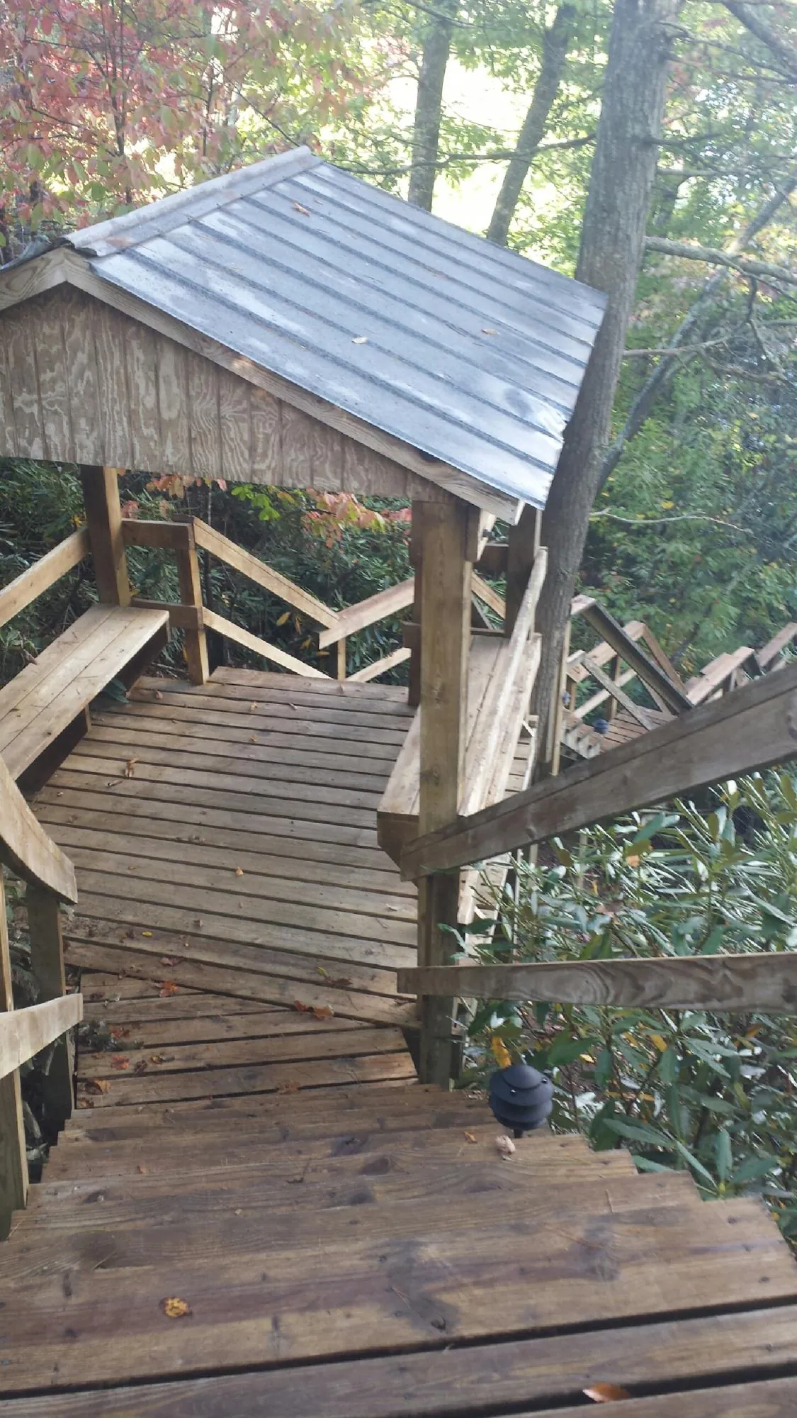 Metal roofed shelter over wooden steps on a wooded walkway — Skylight Repair & Installation work by our crew in Duryea